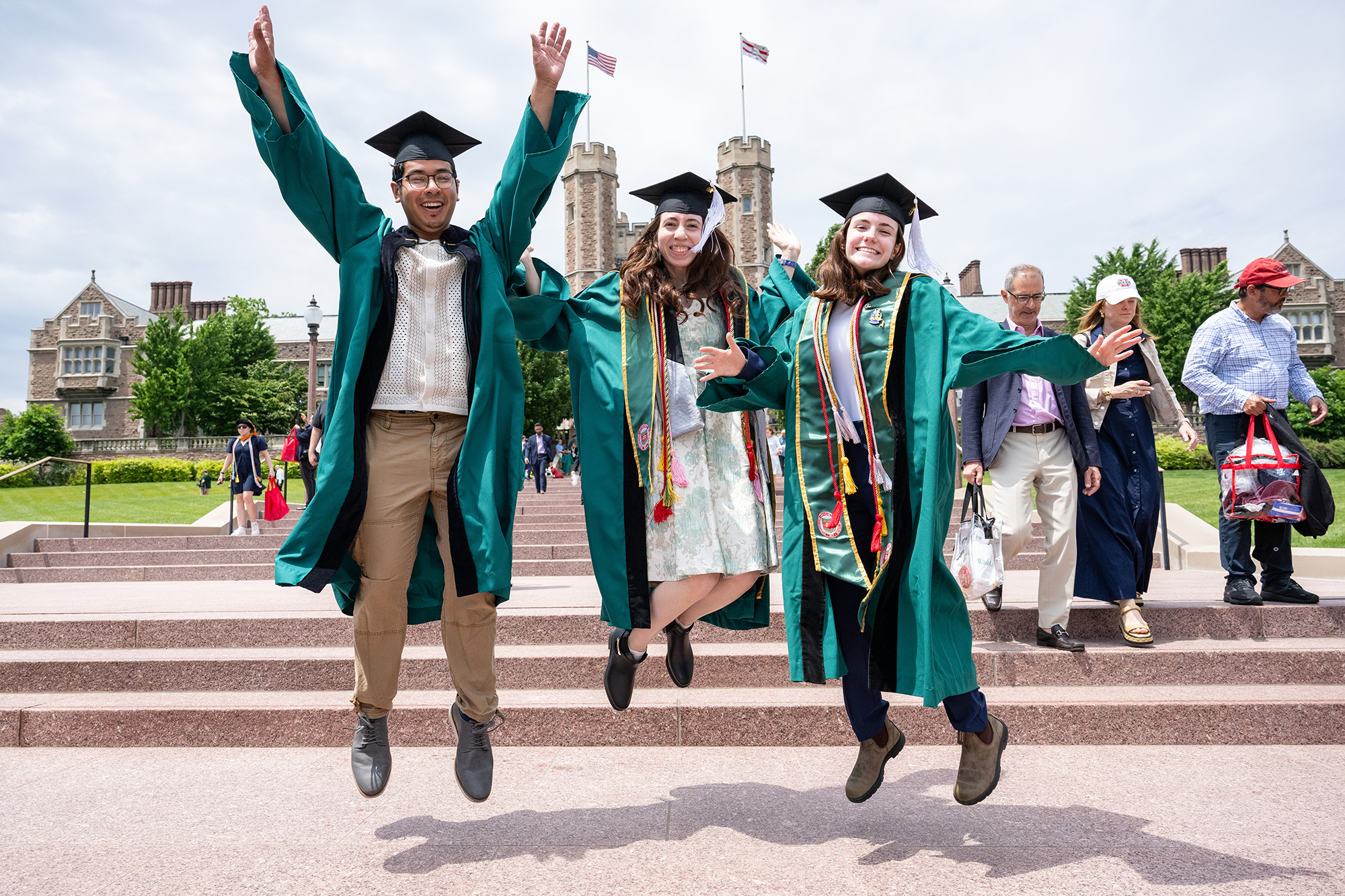 three grads jumping in the air after commencement