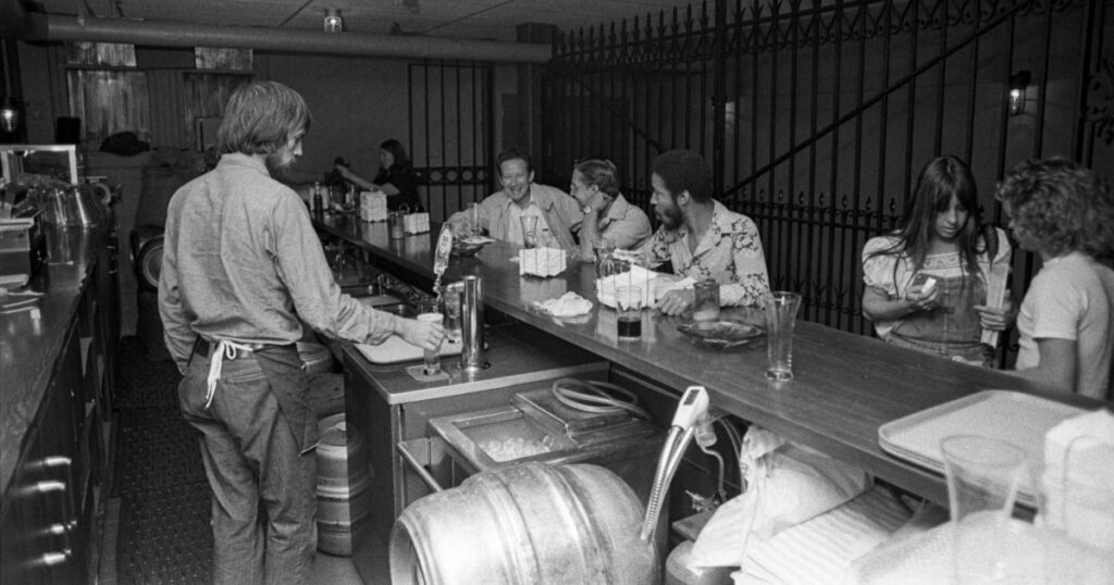 bartender pouring a drink at The Rat in the 1970s