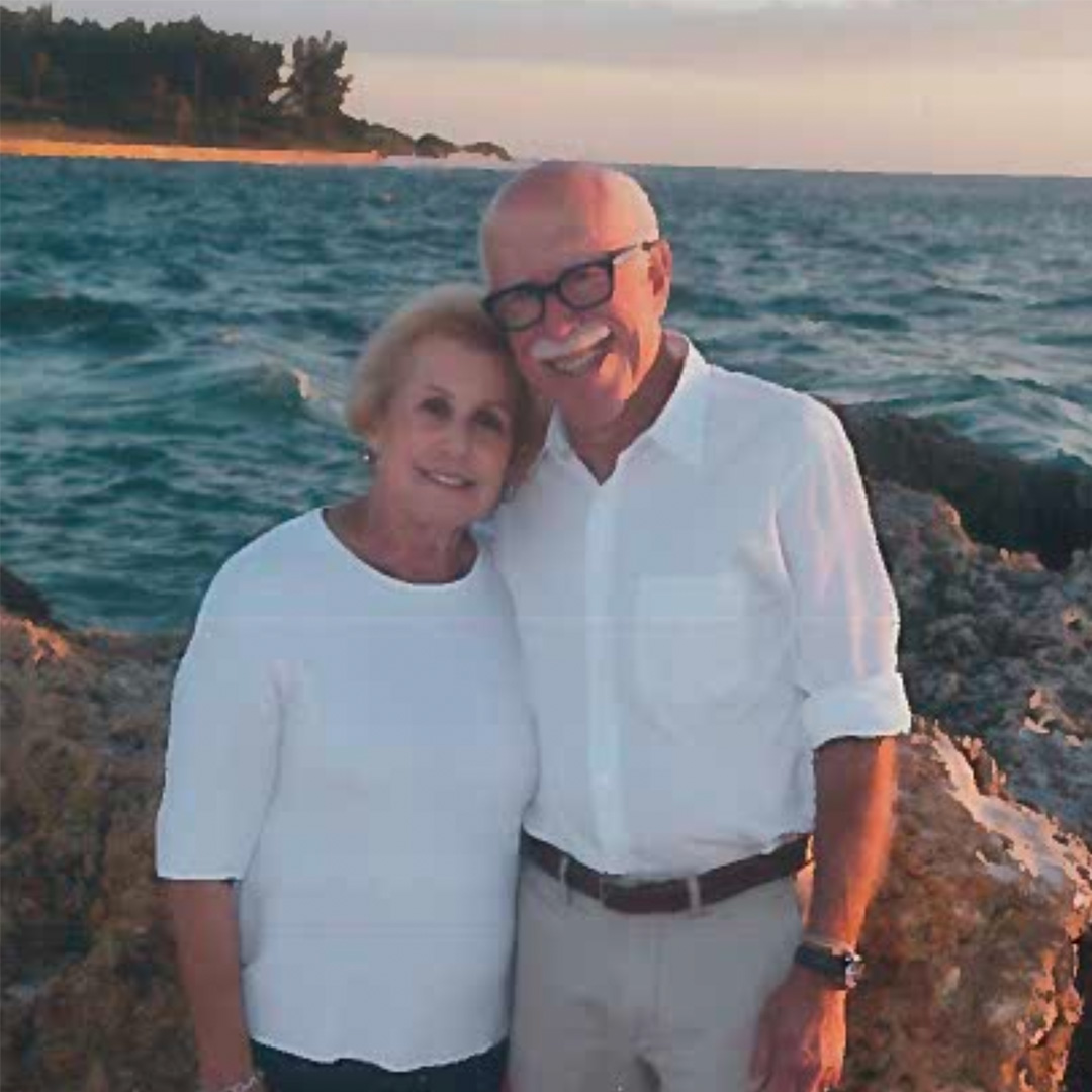 Martin and Jill Sneider pose in front of a coastline.