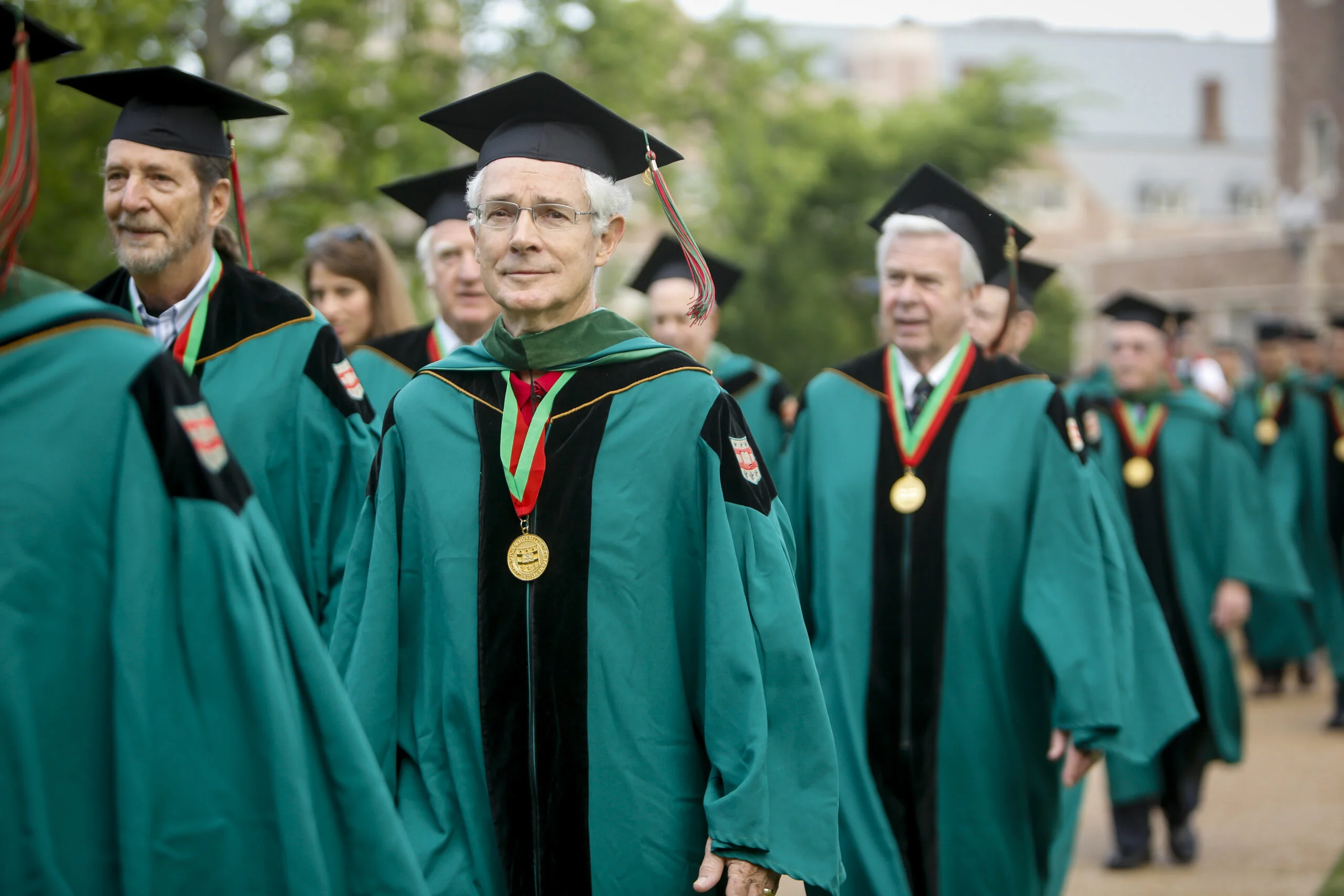 older graduates walk at commencement